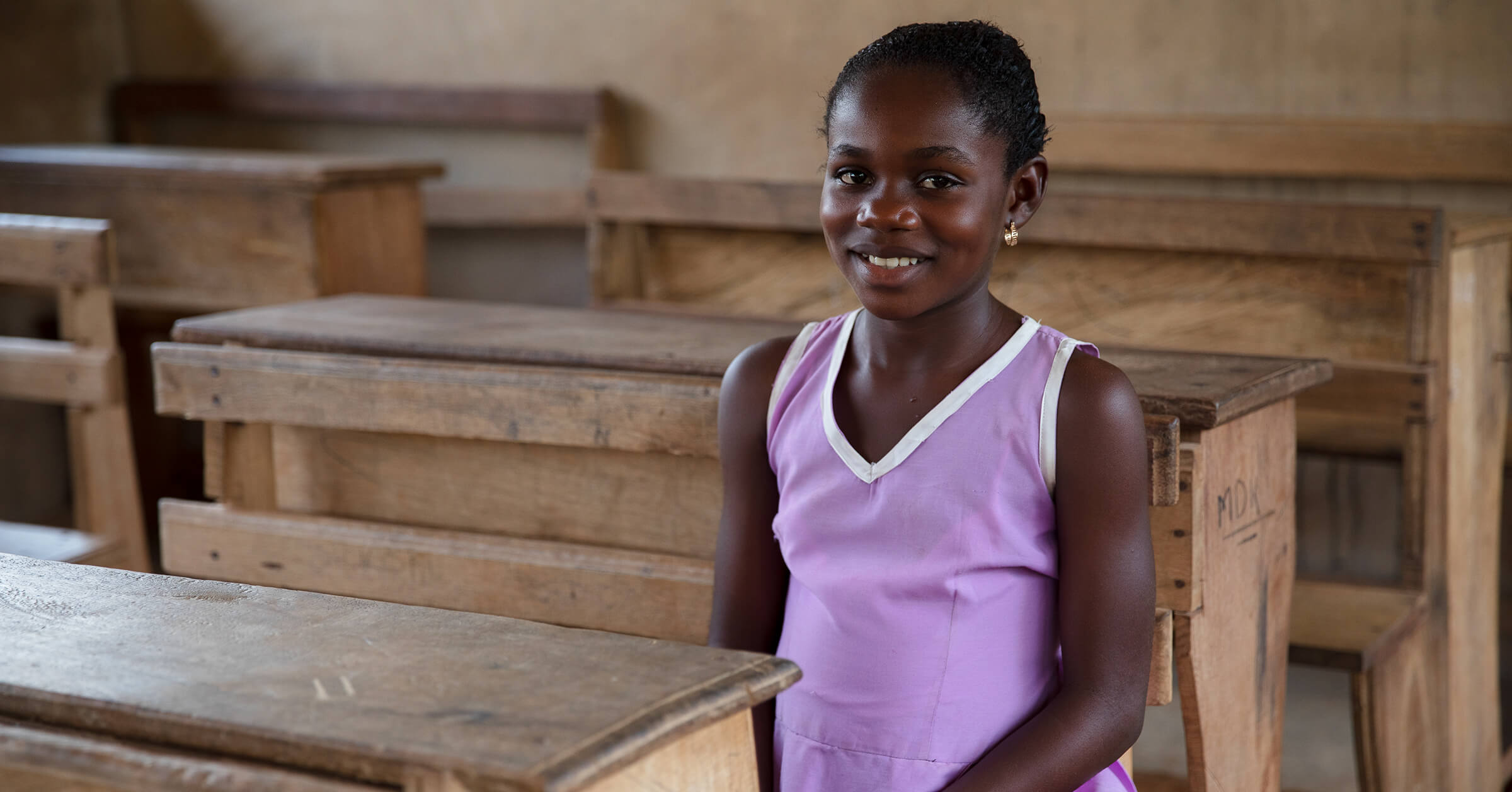 Ghanalainen tyttö istuu koulussa, jonka rakentamiseen on käytetty Reilun kaupan lisää.