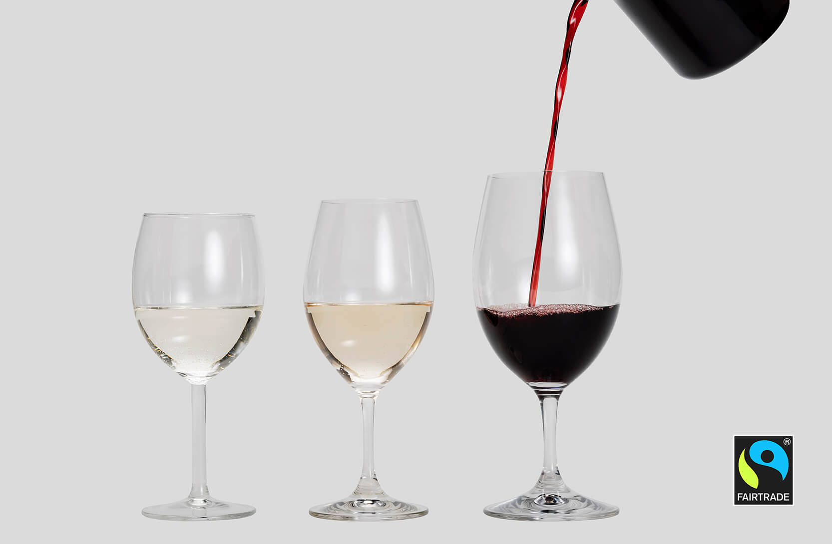 Reilun kaupan viiniä löytyy valkoviininä, roseeviininä ja punaviininä. Kuvassa kolme läpinäkyvää lasia, johon oikealla olevaan lasiin kaadetaan punaviiniä.