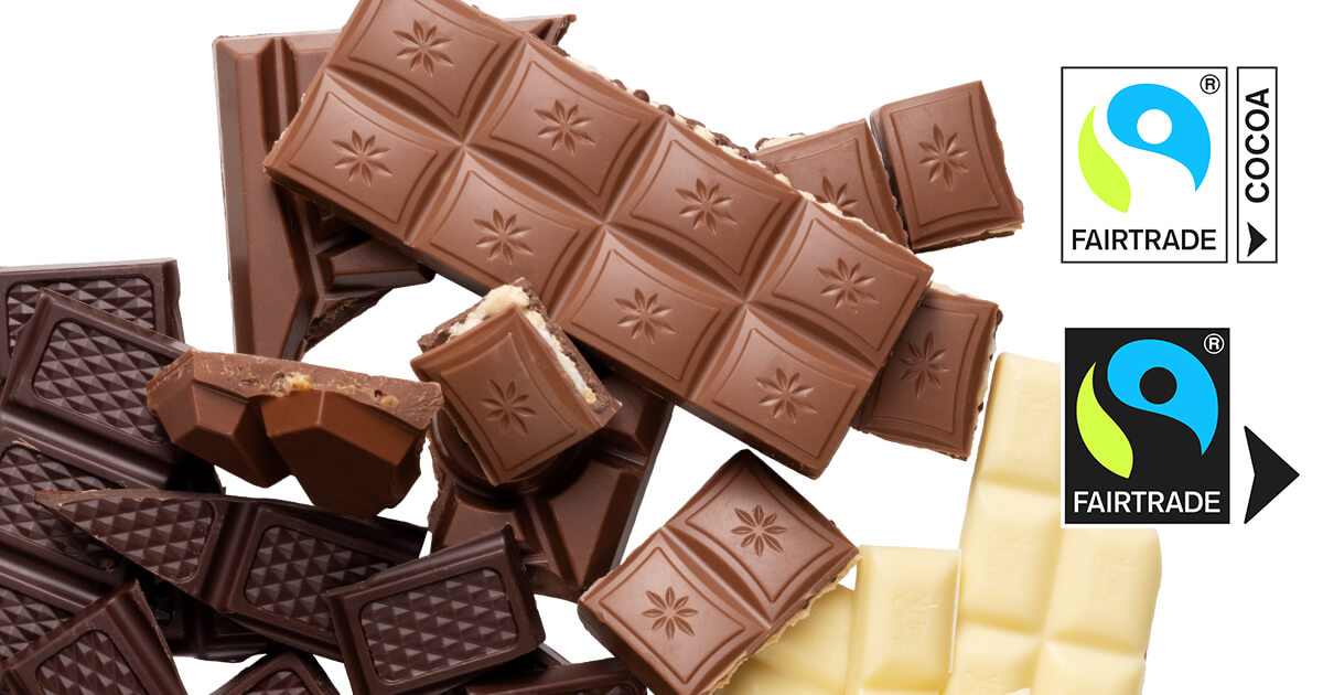 Reilun kaupan suklaata löytyy massabalanssituotteena. Kuvassa on maitosuklaata, tummaa suklaata ja valkoista suklaata sekä Reilun kaupan valkoinen raaka-ainemerkki ja musta sertifiointimerkki nuolella.
